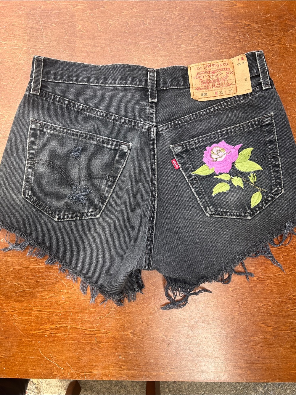 LEVI’S High-Waist Distressed Black Denim Shorts with Embroidered Floral Button